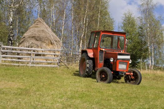 Image of a tractor in a mountain rural area.