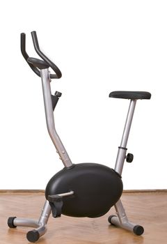 Fitness bicycle on a parquet floor in a gym.