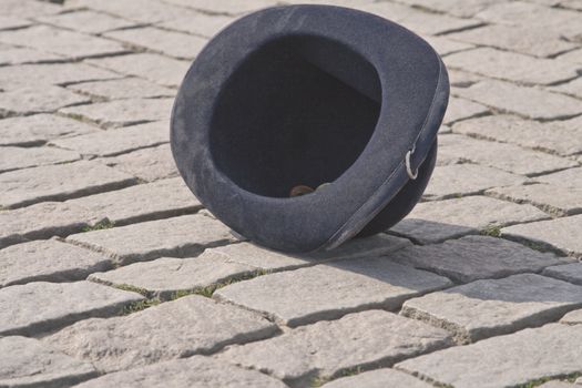 Street artist's black felt hat used for collecting funds in a pavement street. Location:Charles Bridge,Prague.