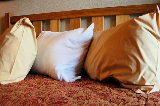 three pillows on a bed in a hotel room