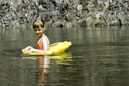 The girl floats on lake with a life buoy