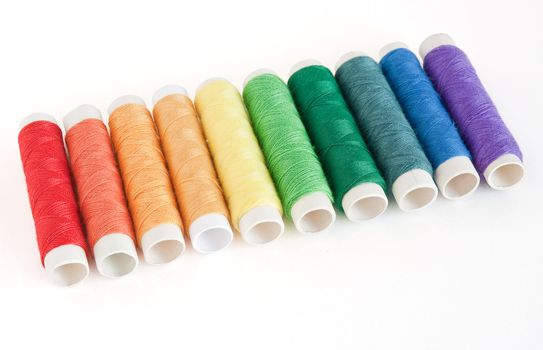 rainbow color spools threads isolated on white background
