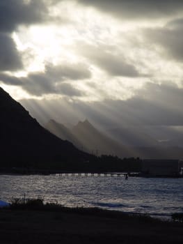 Sun beams shine through the clouds over Hawaii.