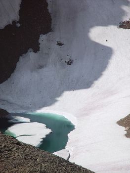 A small glacier in the Rockies calves an ice berg.