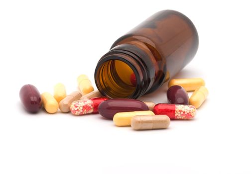 Vial and multi-coloured capsules it is isolated on a white background a close up.