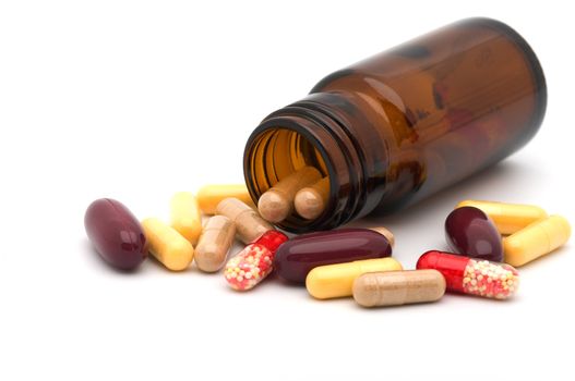 Vial and multi-coloured capsules it is isolated on a white background a close up.