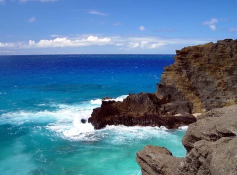 Here the great blue of Neptune’s kingdom battles with the lava rock of Hawaii.