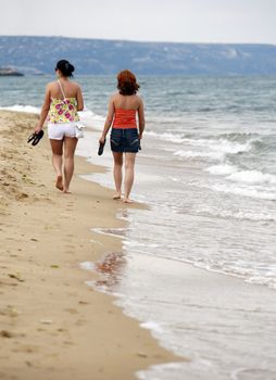 Two girls on coast. Bulgaria. Gold sand