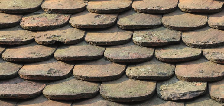 Close-up image of an old roof made of wooden tiles.
