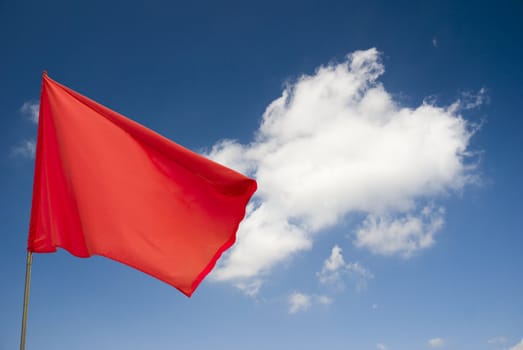 Red flag on blue sky with clouds!