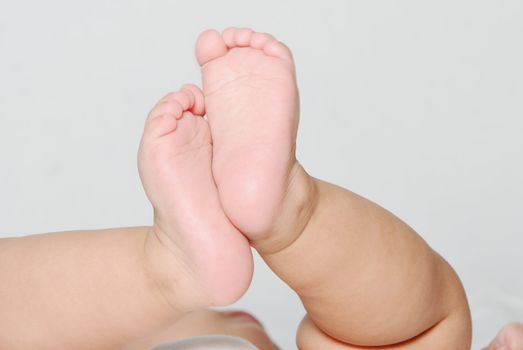 Legs of the baby on a light background