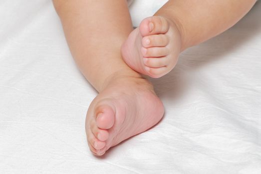 Legs of the baby on a light background