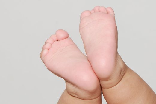 Legs of the baby on a light background