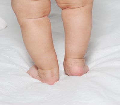 Legs of the baby on a light background