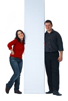 Young woman and man posing and holding white billboard on white