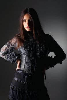 Portrait of a young woman with long hair dressed in lace corset.