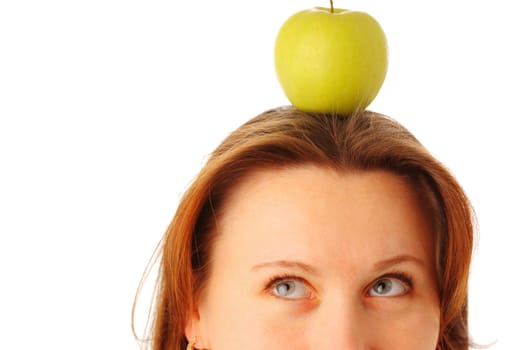 Cropped image of a young attractive woman with a juicy green apple on her head, isolated over white background