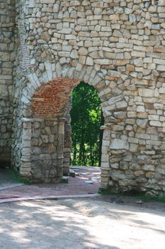 Old stone wall with an arch pass inside