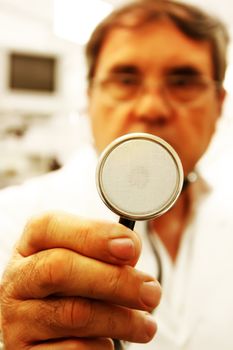 Doctor with an stethoscope in his hand at a hospital room