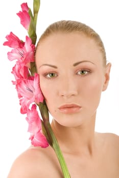 Young woman in spa with fresh pink gladiolus