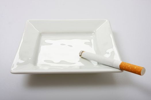 burning cigarette on white ashtray isolated on white