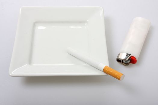 unlit cigarette on white ashtray isolated on white white lighter to the side