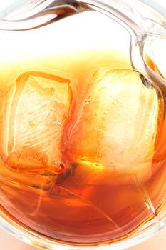 Closeup of whiskey with ice cubes on white background