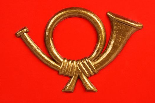 A golden mail symbol on red, A macro shot of a mail emblem on a red mailbox