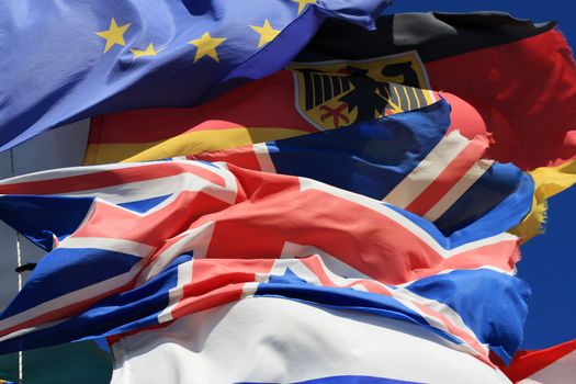 The national flags of France, UK and Germany along with the European Union flag all flying together, thight shot. 