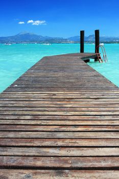 A small jetty on lake Garda Italy, fantastic color in the sky and water. Perfect for any sort of vacation concept