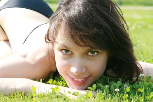 Portrait of a beauty smiling and laying on a grass