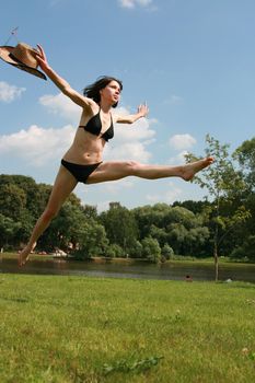 The flying girl in bikini on a background of the sky