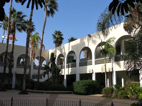 Hotel and patio with palm trees - built in Mediterranean style
