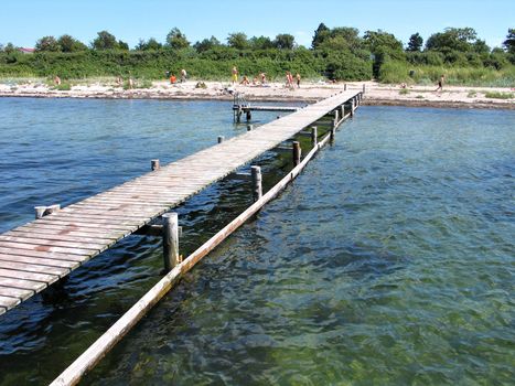 Beach fun - beach with a wooden pier jetty and clear sea water
