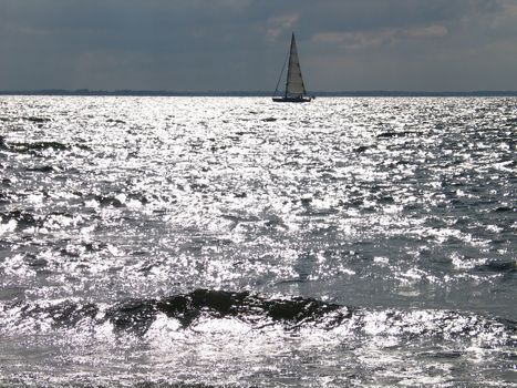 Sailboat in sunset - silver shadows on the water