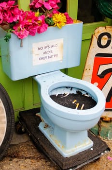An ash tray toilet bowl with flowers.
