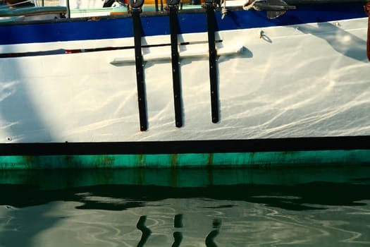 The hull of a boat reflecting in the water.