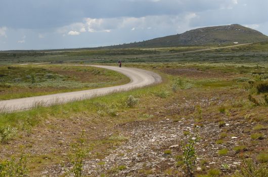Two people passing as the were walking by on a mountain road in Valdres in Norway. 