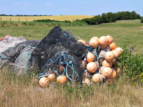 Stack of fishing nets with floats on the beach