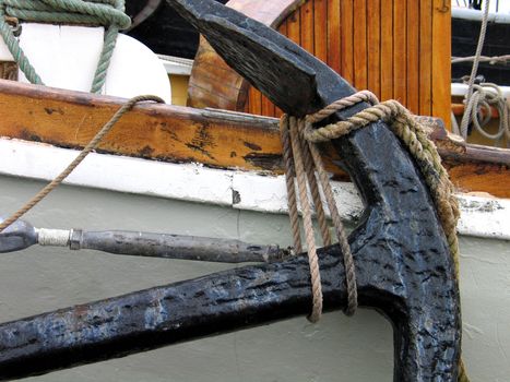 Old metal anchor on a traditional wooden boat