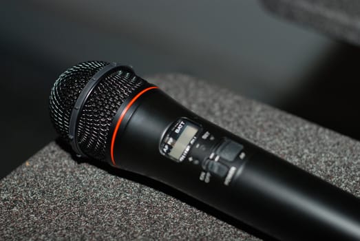 Black wireless microphone laying on a table.