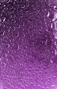 A macro of some beautiful water droplets over a blue background.