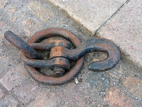 Old anchoring point and hook made of cast iron in a port