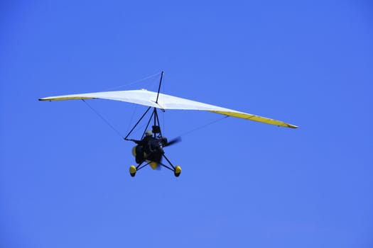 ultralight aircraft in flight against the blue sky
