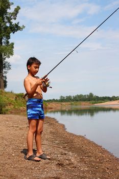 boy fishing with spinning on the river