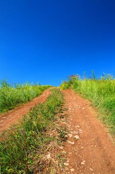 rural road uphill under blue sky