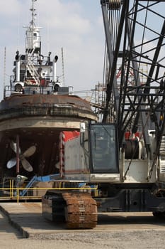a picture of a crane and tug boat on drydock