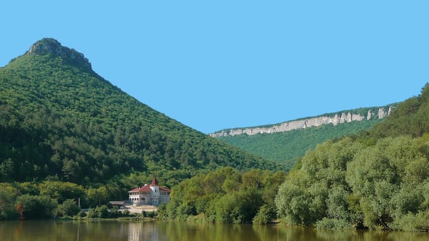 A house is ashore lake in the mountains of Crimea