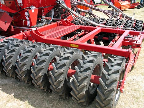 Modern field plow cultivating machine behind a tractor