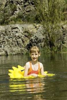 The girl floats on lake with a life buoy